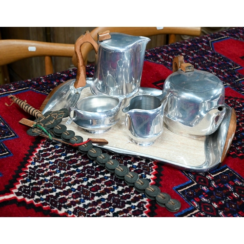 407 - A four piece Piquot-ware set comprising teapot, water pot, cream and sugar on shaped rectangular tra... 