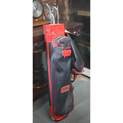 424 - A vintage 'Supadivider' leather golf bag containing five various Dunlop clubs etc.