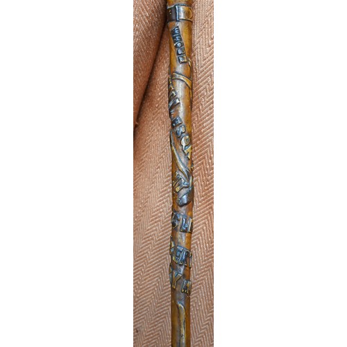 413 - An antique Welsh walking stick, the handle as a dogs head and radially carved in relief 'Whose Matth... 