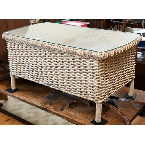 87 - A Laura Ashley rattan wicker glass top coffee table, 102 x 50 x 50 cm high