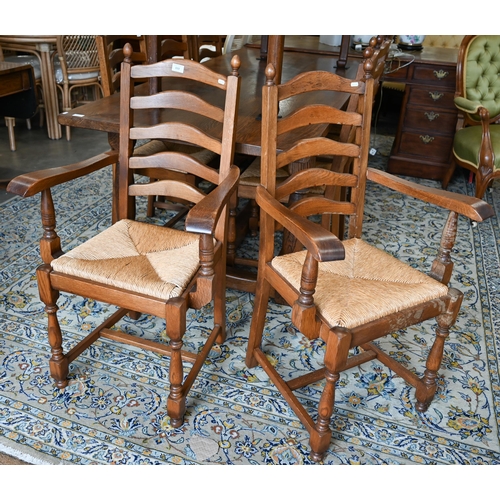 113 - A set of eight oak ladderback dining chairs with rush seats, two carvers and six standard (8)