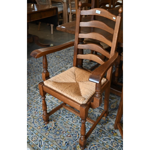 113 - A set of eight oak ladderback dining chairs with rush seats, two carvers and six standard (8)