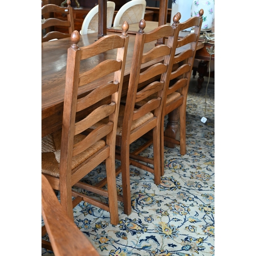 113 - A set of eight oak ladderback dining chairs with rush seats, two carvers and six standard (8)