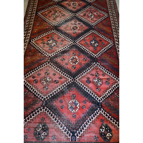 154 - Persian rug, diamond medallions on red ground with cream border, 305 x 152 cm