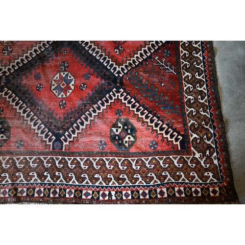 154 - Persian rug, diamond medallions on red ground with cream border, 305 x 152 cm