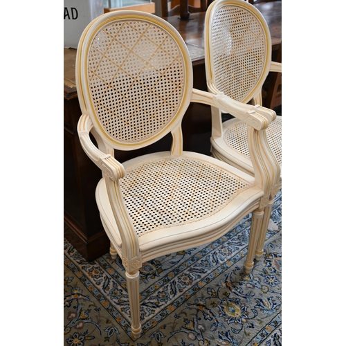 157 - A pair of  French cream painted elbow chairs with caned bases and seats (2)