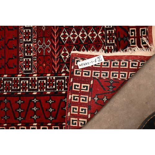 168 - A Persian Turkoman tile design red ground rug, 186 x 126 cm