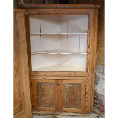 176 - An antique pine corner cabinet with cream painted open shelves over panelled cupboard doors, 130 cm ... 