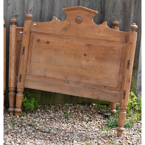 186 - A waxed pine single bed frame, panelled ends with pitched headboard and roundel