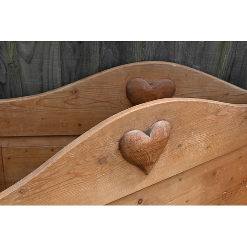 186 - A waxed pine single bed frame, panelled ends with pitched headboard and roundel