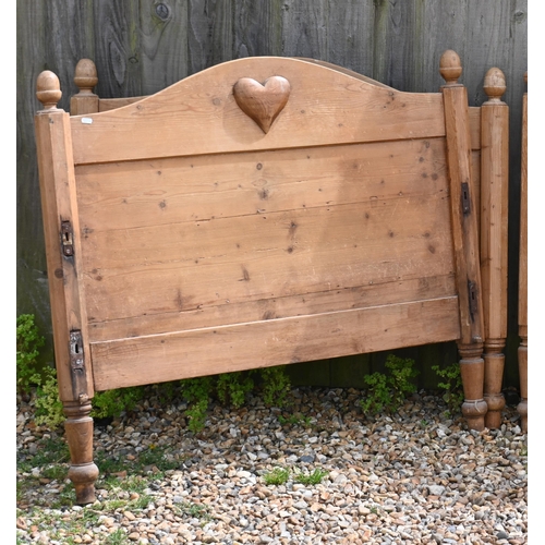 187 - A waxed pine single bet frame with panelled head and foot boards and heart motiff