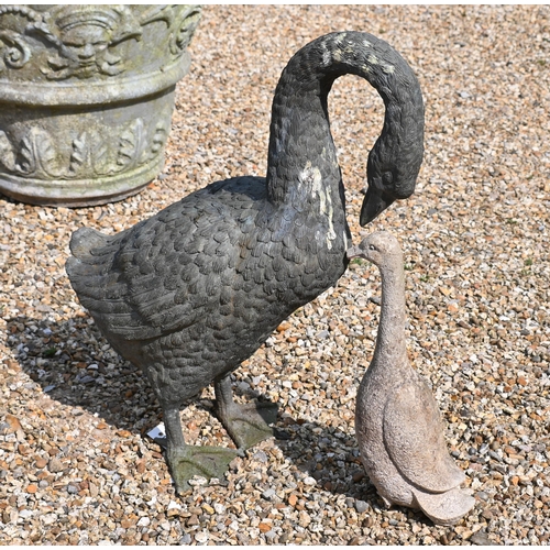 202 - A green bronze patinated garden geese sculpture to/w a small cast stone goose, 58 cm high, a/f (2)