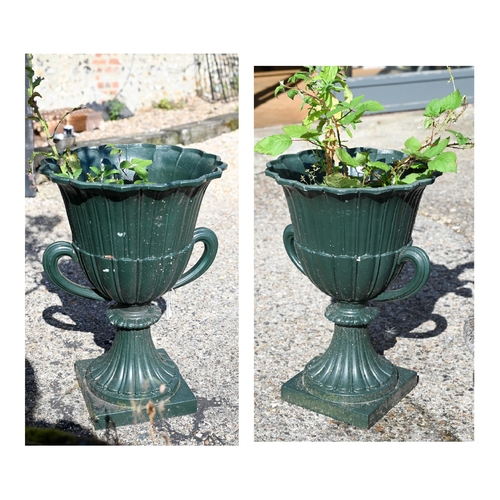 21 - A pair of cast iron twin-handled urn planters, in green paint finish, 63 cm high