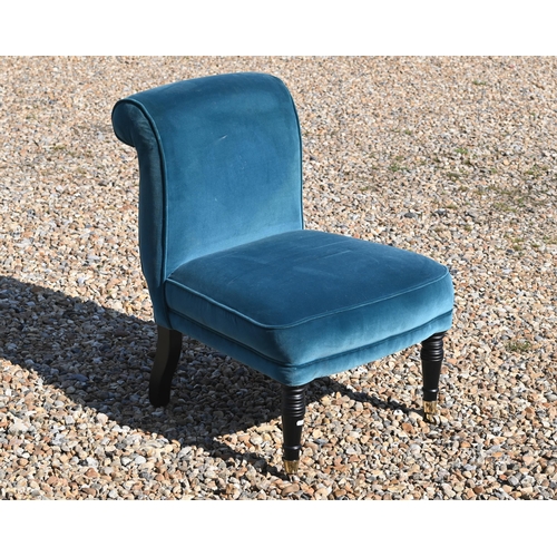 214 - An Edwardian style teal upholstered chair raised on ebonised legs to brass castors