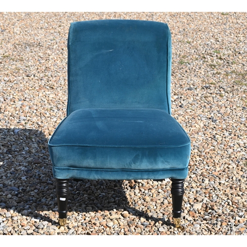 214 - An Edwardian style teal upholstered chair raised on ebonised legs to brass castors