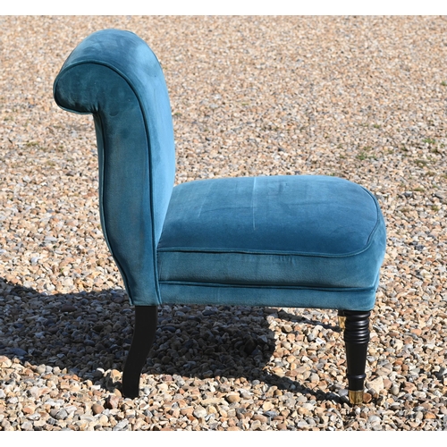 214 - An Edwardian style teal upholstered chair raised on ebonised legs to brass castors