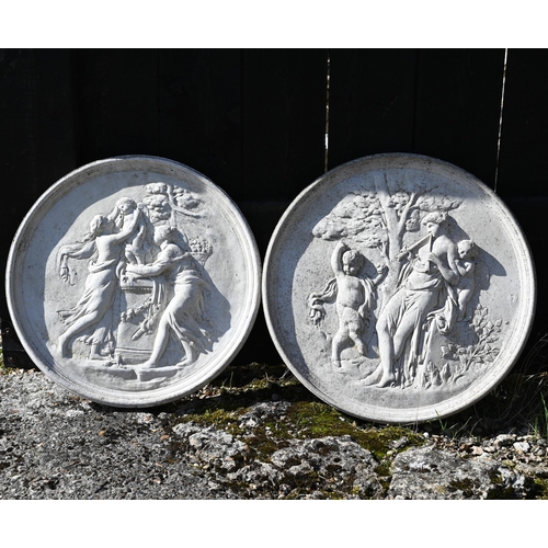 22 - A pair of circular reconstituted stone plaques cast in relief with classical figures, 52 cm dia.