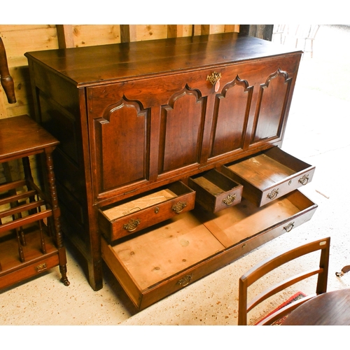 220 - An 18th century oak mule chest, now with four Arabic arch panelled fall front, over an arrangement o... 