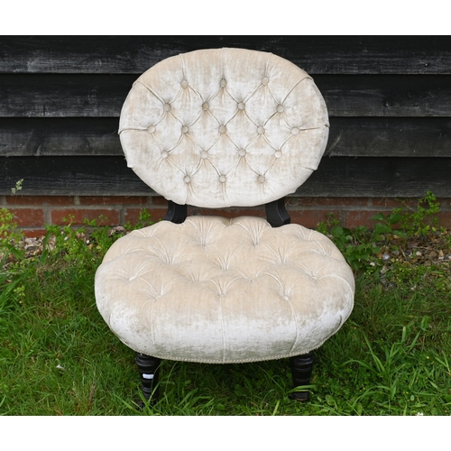 47 - A Victorian buttoned fabric nursing chair raised on ebonised legs to castors