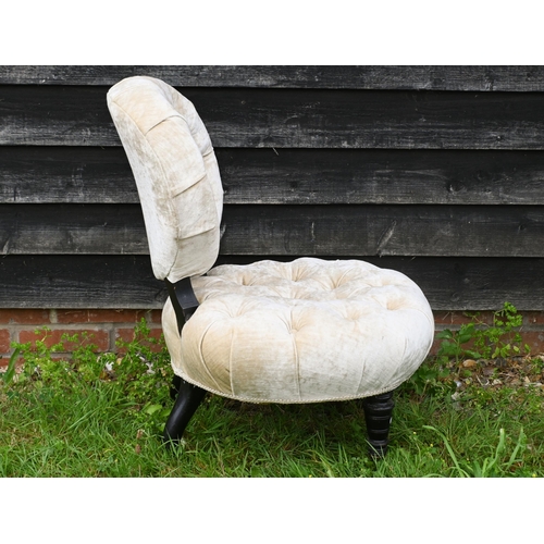 47 - A Victorian buttoned fabric nursing chair raised on ebonised legs to castors