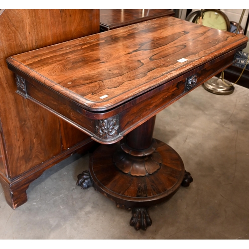 498 - A Regency rosewood card table with rotating folding top, turned column and platform base with lion p... 