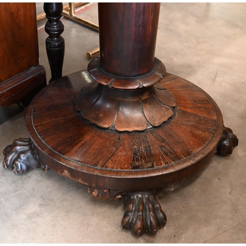 498 - A Regency rosewood card table with rotating folding top, turned column and platform base with lion p... 