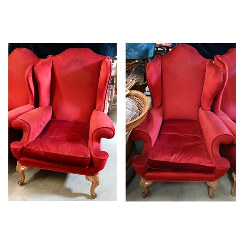 506 - A pair of walnut framed wingback armchairs, burgundy dralon upholstery and acanthus carved front leg... 