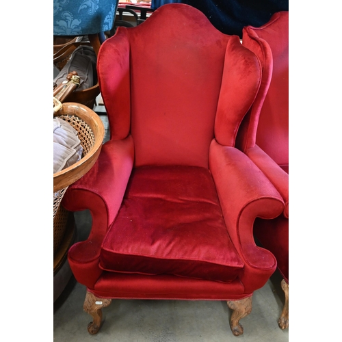 506 - A pair of walnut framed wingback armchairs, burgundy dralon upholstery and acanthus carved front leg... 