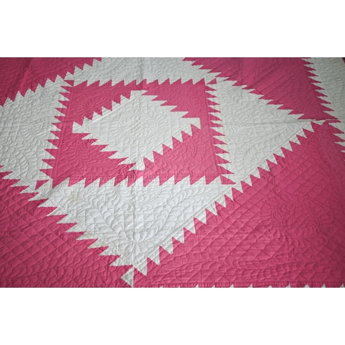 512 - A cerise and white geometric design quilted comforter/quilt, 240 cm x 210 cm