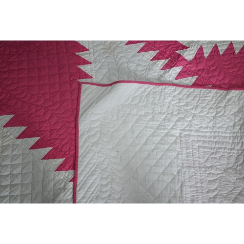 512 - A cerise and white geometric design quilted comforter/quilt, 240 cm x 210 cm