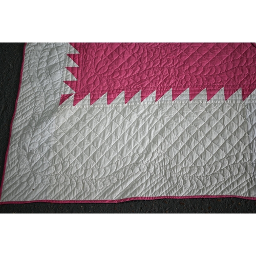 512 - A cerise and white geometric design quilted comforter/quilt, 240 cm x 210 cm