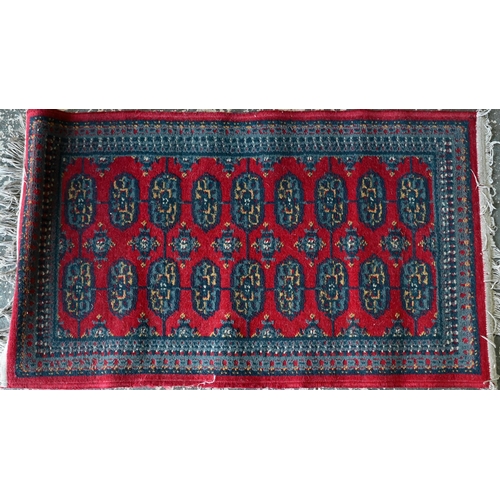 518 - A Turkish geometric design blue ground rug, 110 cm x 59 cm to/w a Pakistan Turkoman design reg groun... 