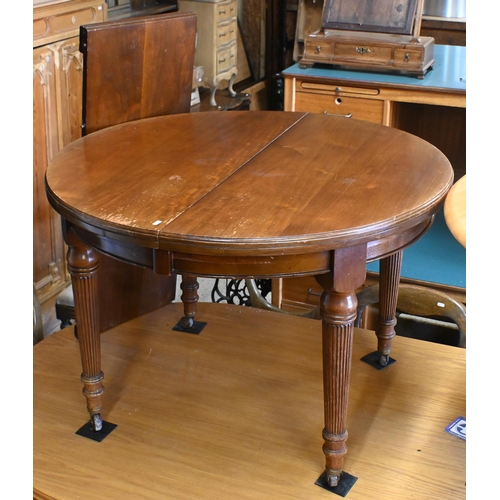 557 - # An Edwardian mahogany extending dining table with leaf, raised on turned and moulded legs to ceram... 