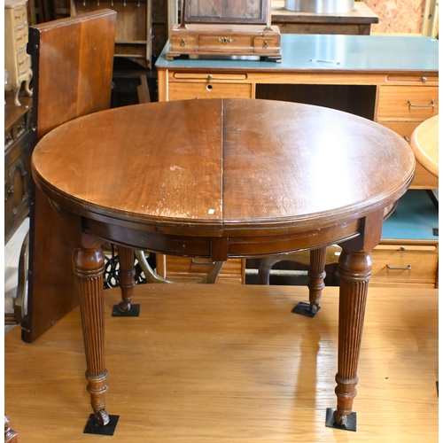 557 - # An Edwardian mahogany extending dining table with leaf, raised on turned and moulded legs to ceram... 