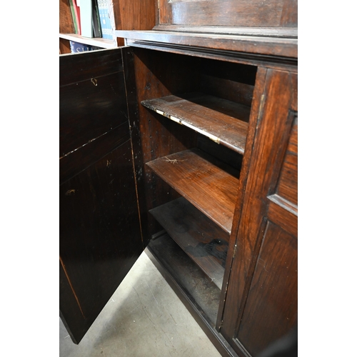 56 - A substantial stained oak dresser in two sections, the top with astragal glazed doors enclosing adju... 