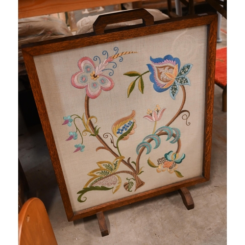 562 - # An oak framed Arts and Crafts style fire screen with floral embroidered panel to/w two magazine ra... 