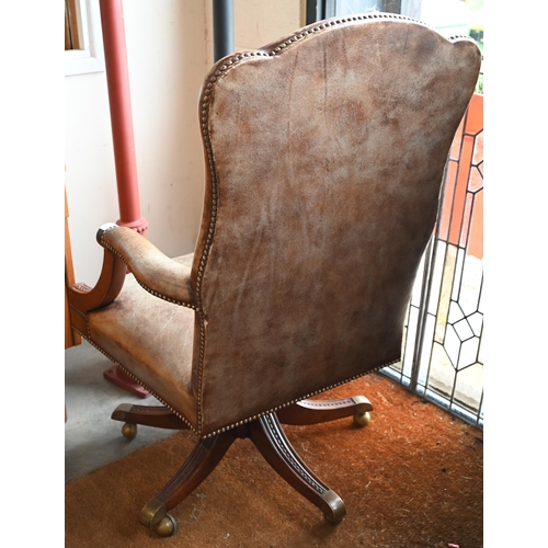 59 - A mahogany framed swivel director's/office chair with studded aged vinyl/leatherette upholstery