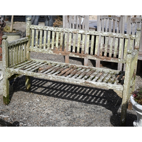 6 - A scarce Edwardian, Heals of London teak two seater garden bench, with moulded post finials, one sea... 