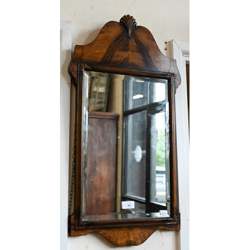 62 - An Edwardian walnut framed mirror with shell carved crest and bevelled plate, 36 x 74 cm