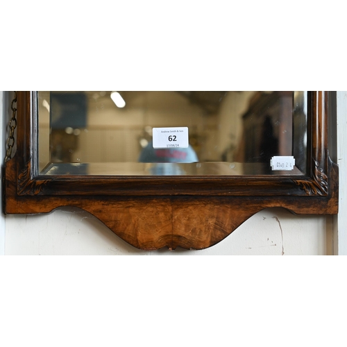 62 - An Edwardian walnut framed mirror with shell carved crest and bevelled plate, 36 x 74 cm