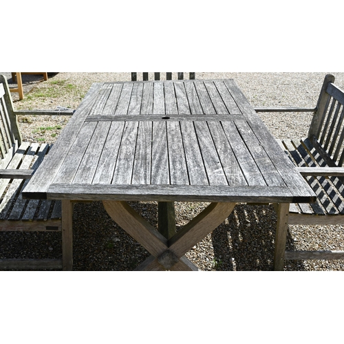 7 - A weathered teak patio dining set comprising dining table on cross-trestle supports, 214 x 108 x 72 ... 