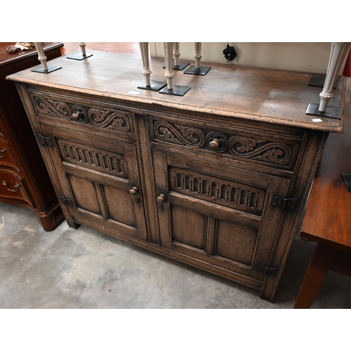 74 - A Tudor style carved oak sideboard with two drawers over panelled cupboard doors, 120 x 44 x 86 cm h... 