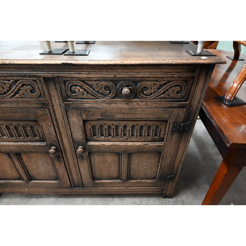 74 - A Tudor style carved oak sideboard with two drawers over panelled cupboard doors, 120 x 44 x 86 cm h... 