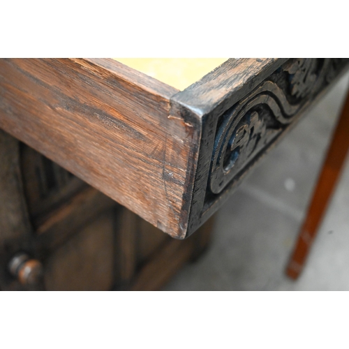 74 - A Tudor style carved oak sideboard with two drawers over panelled cupboard doors, 120 x 44 x 86 cm h... 