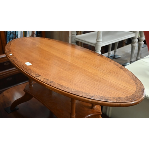 75 - Modern golden oak and burr walnut banded oval coffee table with four turned pillars and quadraform b... 