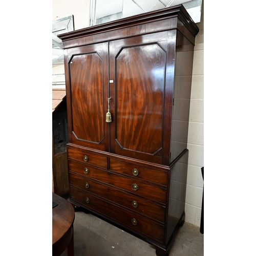 77 - A Regency mahogany linen press with panelled doors enclosing five slides over chest base with two sh... 