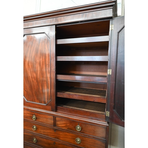 77 - A Regency mahogany linen press with panelled doors enclosing five slides over chest base with two sh... 