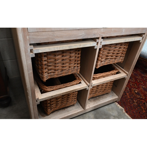 81 - A limed ash pantry cupboard with panelled doors enclosing two shelves (missing brackets) over four b... 