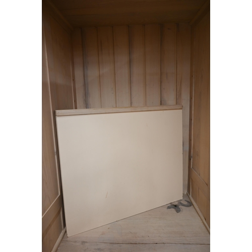 81 - A limed ash pantry cupboard with panelled doors enclosing two shelves (missing brackets) over four b... 