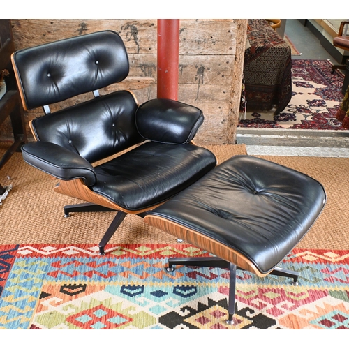 131 - A classic Eames style swivel armchair to/with a matching footstool, buttoned black leather and plywo... 